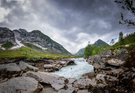 Norwegian mountain landscape panorama glacial river with dark sky