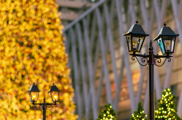 Lantern with blurred colorful Christmas tree in background for Christmas holiday festival.
