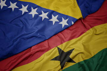 waving colorful flag of ghana and national flag of bosnia and herzegovina.