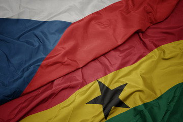 waving colorful flag of ghana and national flag of czech republic.
