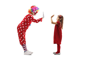 Funny clown making high-five gesture with a little girl