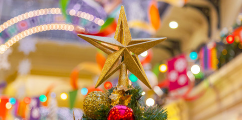 A Christmas decorative - star on the top of A Christmas tree with a beautiful bokeh background