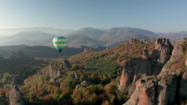 Amazing panoramic video with hot air balloon flying over picturesque rock formation lit by the morning autumn sun, Belogradchik rocks, Bulgaria 