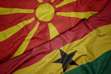 waving colorful flag of ghana and national flag of macedonia.