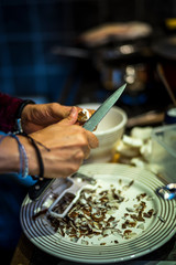 Cooker cutting or choping coconut with a sharpe knife, preparing a delicious meal from sri-lanka