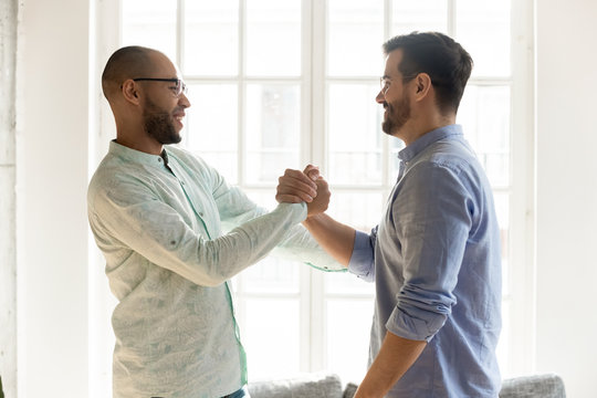 Mixed Race Male Friends In Eyewear Shaking Hands.