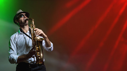 Fototapeta na wymiar Man with Saxophone in colorful light