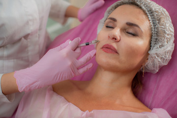A beautiful Mature woman is injected with hyaluronic acid