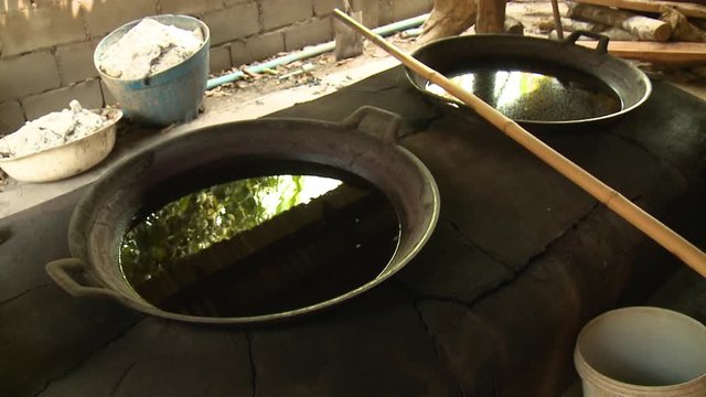 Two large bowls of liquid for dyeing textiles on a stone work space