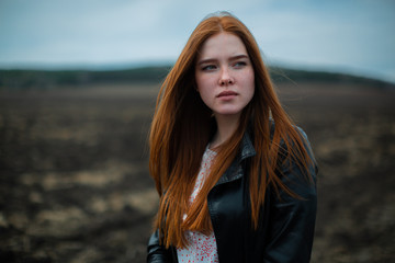 Fototapeta premium Fiery red beauty on the background of a desert mountain landscape.