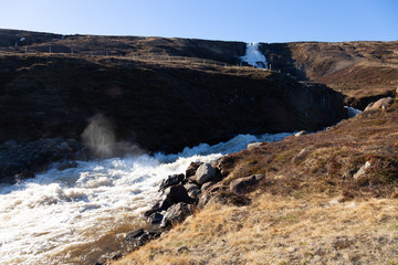 Fototapeta na wymiar Stormy mountain river on a stony rocky calm deserted spring landscape of Iceland