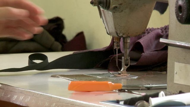 Close up of someone threading a sewing machine needle
