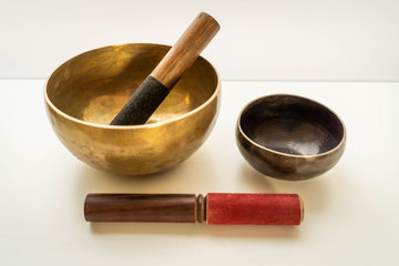 Bronze singing bowls with clappers on white background for meditation or massage (shallow depth of field)