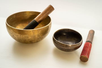 Bronze singing bowls with clappers on white background for meditation or massage (shallow depth of field)