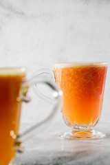 Two glasses of fresh orange fruit juise isolated on bright marble background. Overhead view, copy space. Advertising for cafe menu. Vertical photo.
