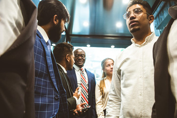 Business team group going on elevator. Business people in a large glass elevator in a modern office. Corporate businessteam and manager in a meeting. © xartproduction