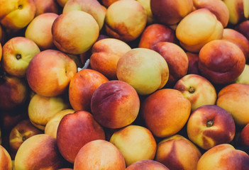 Fresh ripe nectarines or peaches at the market. Selective focus, background.