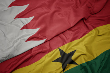 waving colorful flag of ghana and national flag of bahrain.
