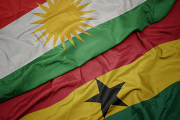 waving colorful flag of ghana and national flag of kurdistan.