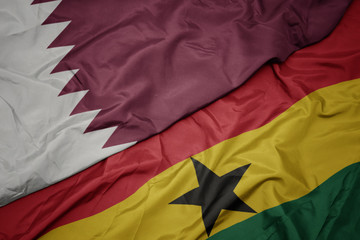 waving colorful flag of ghana and national flag of qatar.