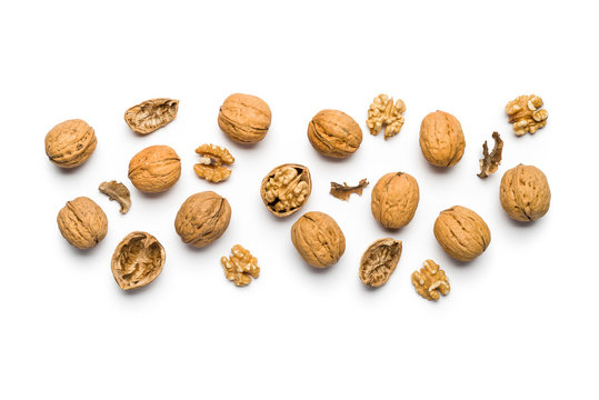 top view of walnuts closed and broken scattered on a white background with copy space