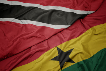 waving colorful flag of ghana and national flag of trinidad and tobago.