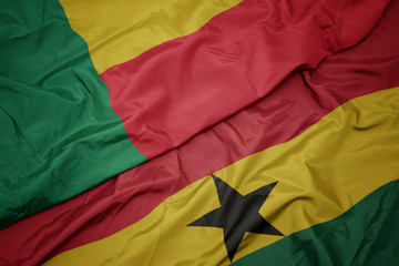 waving colorful flag of ghana and national flag of benin.