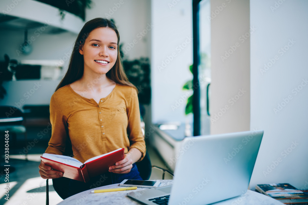 Poster happy female student studying language at coworking space searching information via netbook and prep