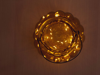 Obraz na płótnie Canvas Warm fairy lights in gold glass bowl