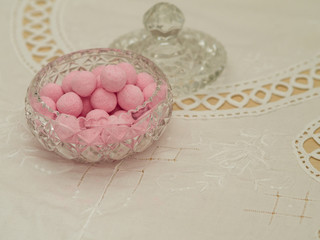 Fototapeta na wymiar Strawberry bonbons in a glass dish on a traditional tablecloth