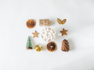 Flat lay Christmas composition - star cookie, gift, dry orange slices, mug with hot drink and marshmallows, pine cone and Christmas fir on white background. top view