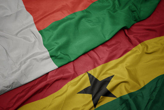 waving colorful flag of ghana and national flag of madagascar.