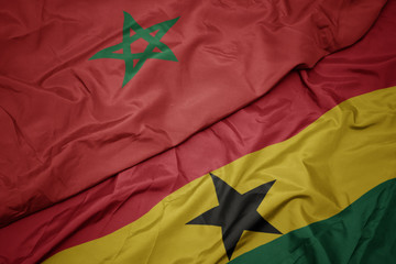 waving colorful flag of ghana and national flag of morocco.