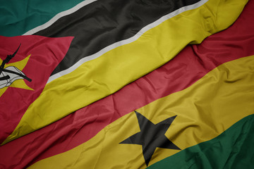 waving colorful flag of ghana and national flag of mozambique.