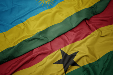 waving colorful flag of ghana and national flag of rwanda.