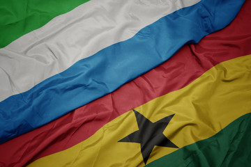 waving colorful flag of ghana and national flag of sierra leone.