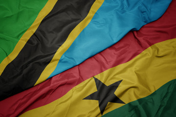 waving colorful flag of ghana and national flag of tanzania.