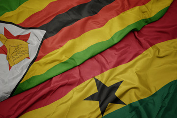 waving colorful flag of ghana and national flag of zimbabwe.