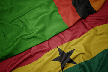waving colorful flag of ghana and national flag of zambia.