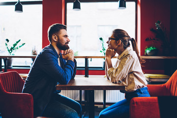 Side view of happy couple in love looking at each other and enjoying leisure time together in...