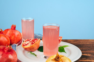 Glass of pomegranate juice and fruits on a table
