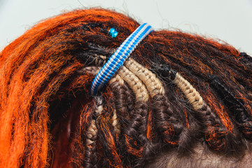Red fiery natural dreadlocks and pigtails with decorations at the scalp. Orange dreadlocks and...