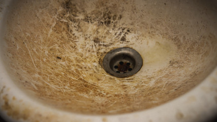 The close up view of the dirty stain inside of the toilet sink in the house. Yellow limescale stain.