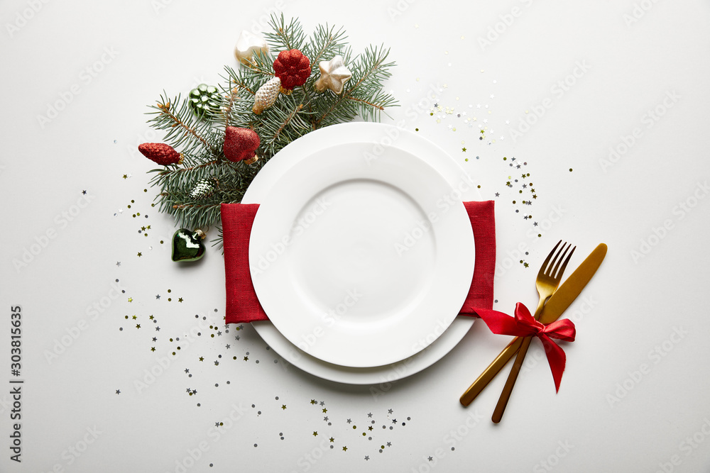 Wall mural top view of festive christmas table setting on white background with decorated pine branch and confe
