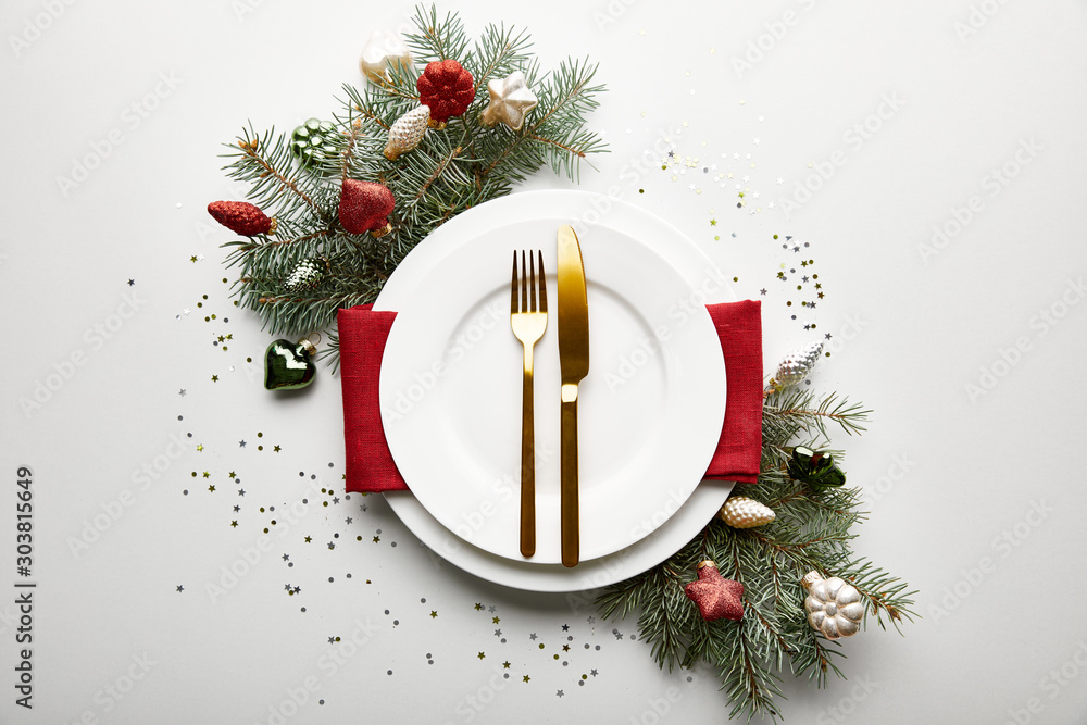Wall mural top view of festive christmas table setting on white background with decorated pine branch and confe