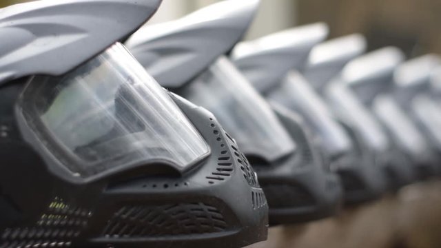 Selective focus close up view of many paintball protective masks  in a row