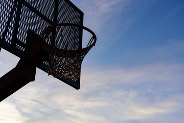 Fototapeta na wymiar Basketball hoop on sunset sky