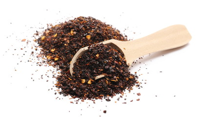 Roasted ground dry chili pepper pile, spicy chopped paprika with wooden spoon isolated on white background
