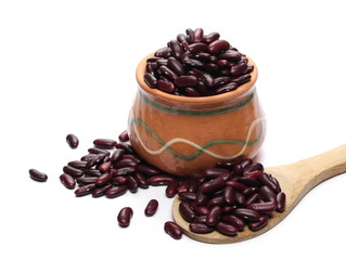 Red kidney beans in clay pot, bowl with wooden spoon isolated on white background