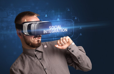 Businessman looking through Virtual Reality glasses with SOCIAL INTEGRATION inscription, social networking concept